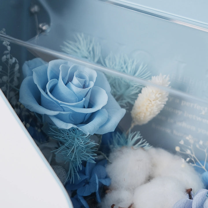 Close-up of preserved blue hydrangeas and complementary flowers from the envelope box