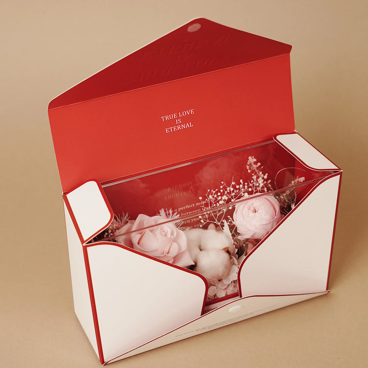 Pink floral design presented inside red envelope-style box with quote detail